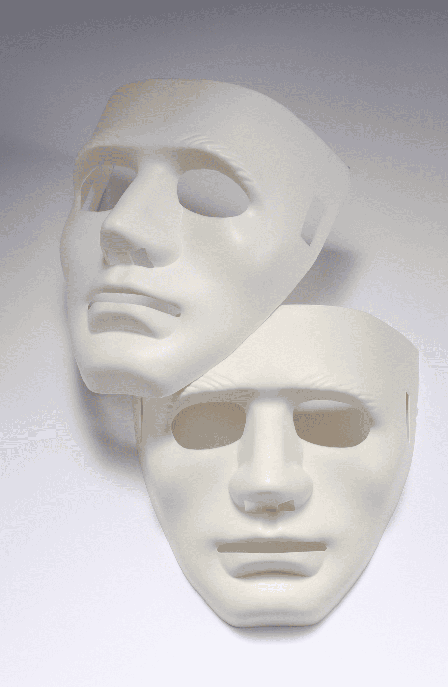 A pair of white, happy-sad, drama masks on a graded white background