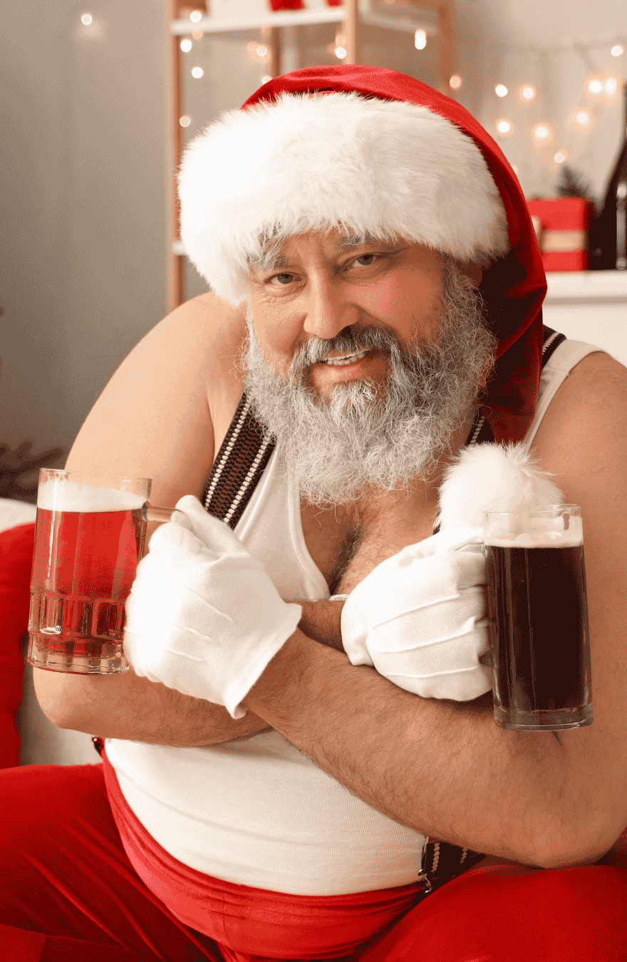Father Christmas, Santa, in a vest and santa hat with a beer in each hand with his arms folded across his chest in a funny provocative pose